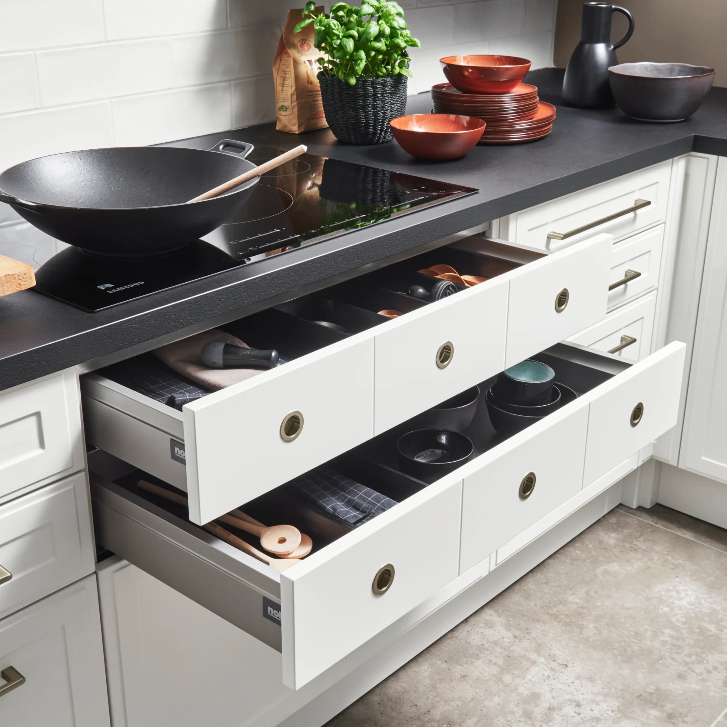 A modern kitchen with open drawers and cooking utensils, Nolte Kitchen.