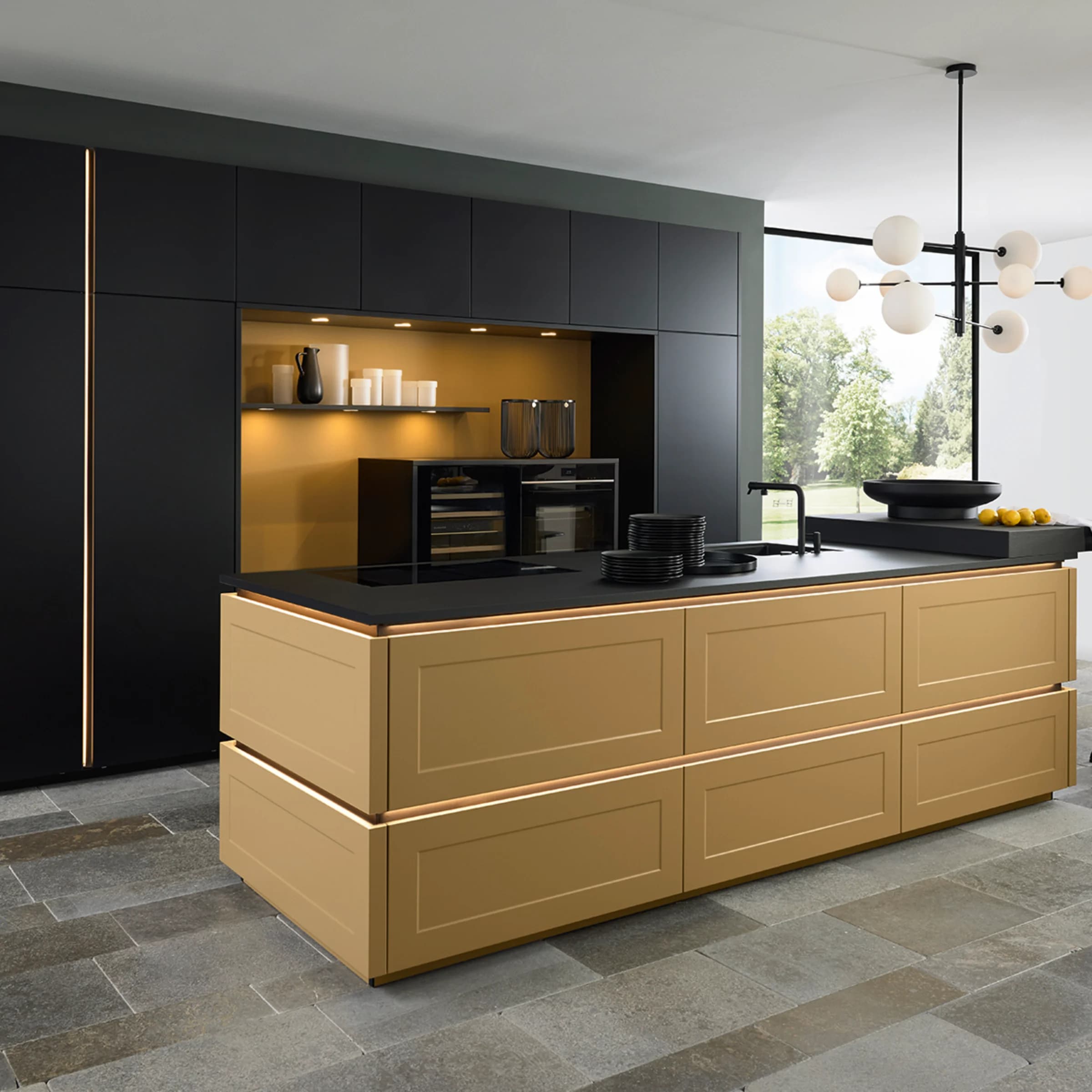 Modern kitchen with a gold island and black cabinets, lit by a pendant light. Nolte Kitchen.