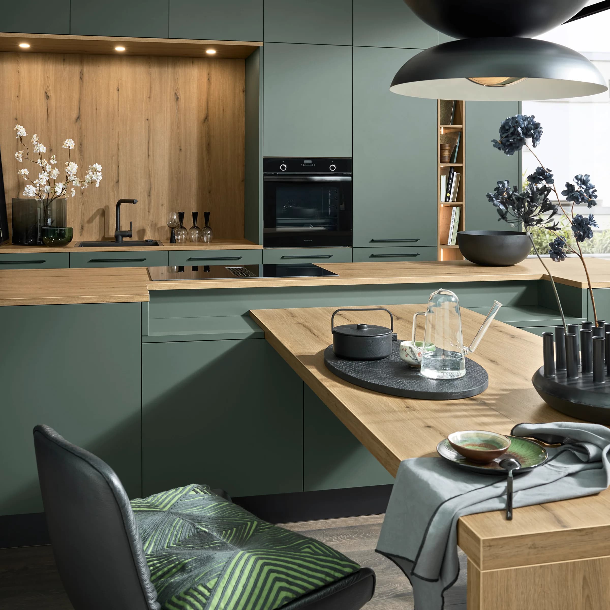A modern green kitchen with wood accents and stylish decor by Nolte Kitchen.