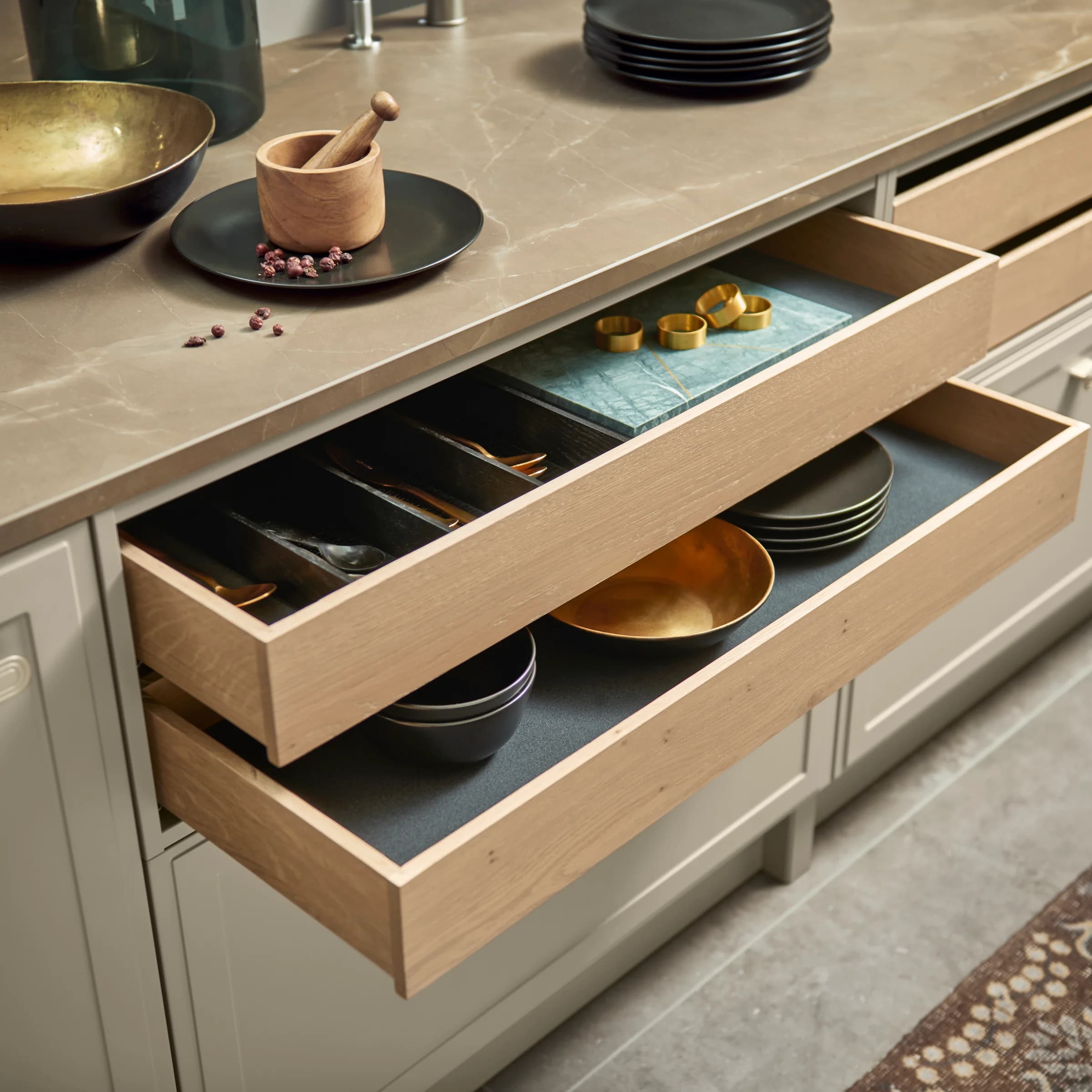 An elegant kitchen with open drawers showcasing stylish storage solutions by Nolte Kitchen.
